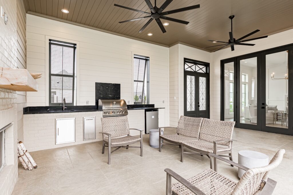 Covered outdoor living space built by Dupree Construction featuring a fireplace, seating area, and patio.